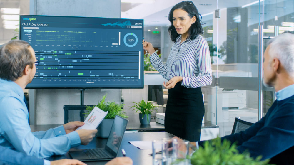 Female presenting VoiceBase call flow dashboard in meeting